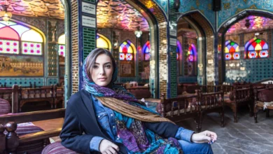 Woman Sitting In Colourful Restaurant With Stained Glass Windows
