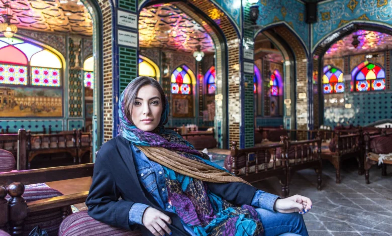 Woman Sitting In Colourful Restaurant With Stained Glass Windows