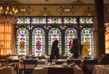 Local women dressed in chador gathered for lunch in Restaurant Shahrzad, Isfahan, Iran Intricate stainedc glass windows